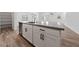 Kitchen island with stainless steel dishwasher, sink, grey countertop, and white cabinetry in an open layout home at 9839 Berkley Brook Ct, Las Vegas, NV 89141