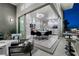 Open-air balcony with seating area and glass railings offers views into a modern dining room and living space at , Las Vegas, NV 89135
