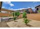 The backyard features a covered patio, brick walls, desert landscaping, and several young trees at 10182 Skye Run Ave, Las Vegas, NV 89166