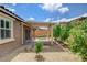 A backyard area with desert landscaping, a covered patio, and access to the house through sliding glass doors at 10182 Skye Run Ave, Las Vegas, NV 89166