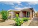 A well-maintained backyard with desert landscaping, colorful flowers, and a covered patio with brick pavers at 10182 Skye Run Ave, Las Vegas, NV 89166