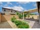 A well-maintained backyard with colorful flowers, a covered patio, and desert landscaping at 10182 Skye Run Ave, Las Vegas, NV 89166