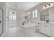 Bright bathroom featuring dual vanities, a soaking tub, and white marble floors at 10182 Skye Run Ave, Las Vegas, NV 89166