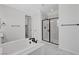 Bright bathroom featuring a soaking tub, glass enclosed shower, and white marble floors at 10182 Skye Run Ave, Las Vegas, NV 89166