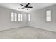 Bright bedroom with neutral carpet, ceiling fan, and shuttered windows at 10182 Skye Run Ave, Las Vegas, NV 89166