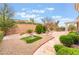 Backyard featuring well-manicured landscaping, lush greenery, custom stone hardscape and manicured bushes at 10508 Snyder Ave, Las Vegas, NV 89134