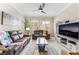 Cozy living room featuring tile flooring, a ceiling fan, and large windows with shutters at 10508 Snyder Ave, Las Vegas, NV 89134