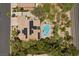 A beautiful aerial view of a home with a pool, solar panels, and lush greenery at 10674 Chillingham Dr, Las Vegas, NV 89183