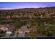 A beautiful aerial view of a home with solar panels, desert landscaping, and a three-car garage at 10674 Chillingham Dr, Las Vegas, NV 89183