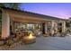 Covered back patio with a stone fire pit and outdoor seating area at 10674 Chillingham Dr, Las Vegas, NV 89183