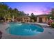 Resort-style backyard featuring a sparkling pool, spa, covered patio, and ample seating areas at 10674 Chillingham Dr, Las Vegas, NV 89183