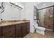 Bathroom showing a glass enclosed shower, granite countertops and dark wood cabinets at 10674 Chillingham Dr, Las Vegas, NV 89183
