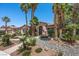 Beautiful desert home with lush landscaping, mature palm trees, and an inviting front entryway at 10674 Chillingham Dr, Las Vegas, NV 89183
