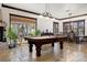Game room with a pool table and abundant natural light from the large windows at 10674 Chillingham Dr, Las Vegas, NV 89183