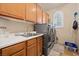 A well-equipped laundry room with a sink, washer, dryer and ample cabinet space at 10674 Chillingham Dr, Las Vegas, NV 89183