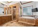Elegant bathroom with tiled shower, tub, vanity, and travertine floors at 10674 Chillingham Dr, Las Vegas, NV 89183