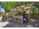 Inviting outdoor kitchen featuring a covered bar, seating for five, and lush greenery at 10674 Chillingham Dr, Las Vegas, NV 89183