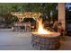 Outdoor kitchen and bar area with a brick fire pit in the foreground at 10674 Chillingham Dr, Las Vegas, NV 89183