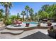 Lush backyard oasis with pool, seating areas, and mature trees, perfect for summer relaxation at 10674 Chillingham Dr, Las Vegas, NV 89183