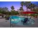 Inviting pool with a seating area in shallow water surrounded by palm trees at 10674 Chillingham Dr, Las Vegas, NV 89183