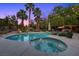 Sparkling pool and spa surrounded by lush landscaping and ambient lighting, perfect for relaxation at 10674 Chillingham Dr, Las Vegas, NV 89183