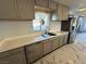 Close up of kitchen featuring stainless steel dishwasher and refrigerator with white countertops and gray cabinets at 1304 Bonita Ave, Las Vegas, NV 89104