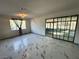 Bright living room featuring marble-like tile flooring and a sliding glass doors opening to an enclosed patio at 1304 Bonita Ave, Las Vegas, NV 89104