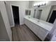 Bathroom features a dual sink vanity with quartz countertops and wood-look floors at 1345 N Hollywood Blvd, Las Vegas, NV 89110