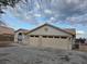 A neutral stucco home featuring a tile roof, an attached two-car garage, and a concrete driveway at 1345 N Hollywood Blvd, Las Vegas, NV 89110