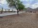 Large lot with a long driveway and mountain views, featuring desert landscaping and native trees at 1345 N Hollywood Blvd, Las Vegas, NV 89110
