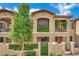 Inviting townhome exterior featuring stucco facade, small balconies, and charming courtyard entrance at 1525 Spiced Wine Ave # 12103, Henderson, NV 89074