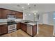 Open kitchen with wood floors, stainless steel appliances, and a granite breakfast bar at 1525 Spiced Wine Ave # 12103, Henderson, NV 89074