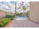 Backyard featuring a brick patio, beautiful landscaping, and a sparkling pool with a shade sail at 155 Fallon Dr, Henderson, NV 89074