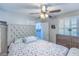 Bright bedroom features a padded headboard, ceiling fan and dresser, with bright light coming through the window at 155 Fallon Dr, Henderson, NV 89074