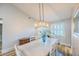 Charming dining room with modern chandelier, white table and chairs, and window at 155 Fallon Dr, Henderson, NV 89074