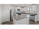 Stylish kitchen with stainless steel appliances, gray counters, white cabinetry, and a center island at 1705 Desert Path Ave, North Las Vegas, NV 89032