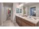 Elegant bathroom with double sinks, a large mirror, and access to the closet at 173 Petaluma Valley Dr, Las Vegas, NV 89138