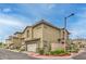 Side view of a tan two-story townhouse featuring an attached garage and manicured landscaping at 173 Petaluma Valley Dr, Las Vegas, NV 89138