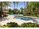 Enjoy a relaxing day at the community pool and hot tub, surrounded by lush greenery and palm trees at 1912 Summer Pine Ct # 102, Las Vegas, NV 89134