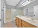 Bathroom featuring double sinks, a large mirror, and a shower over tub, with a neutral color scheme at 2328 Fossil Canyon Dr, Henderson, NV 89052
