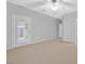 A bright bedroom with neutral paint colors, carpet, and a door to the outside at 2328 Fossil Canyon Dr, Henderson, NV 89052