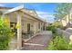 Covered patio with stone pavers, a dining set, and a lush landscaped yard at 2328 Fossil Canyon Dr, Henderson, NV 89052