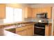 Traditional kitchen featuring stainless steel appliances, wood cabinets and a dual bowl sink under the window at 3001 Anna Bay Dr, Las Vegas, NV 89134