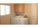 This laundry room features both a washing machine and dryer with overhead storage at 3001 Anna Bay Dr, Las Vegas, NV 89134
