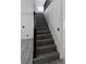 View of a modern staircase with gray wood-look treads, white walls and a black railing at 3217 Harbor Vista St, Las Vegas, NV 89117
