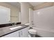 Bathroom featuring a tub with white tile surround and black countertop sink at 3760 Paseo De Paz Ave, Las Vegas, NV 89115