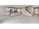 Open-concept living room with sleek kitchen, island, and modern staircase for seamless living at 3760 Paseo De Paz Ave, Las Vegas, NV 89115