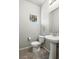 Well-lit bathroom with a pedestal sink and a toilet, featuring modern fixtures and a neutral color palette at 4039 Beech Fern Ave, North Las Vegas, NV 89084