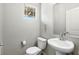 Well-lit powder room with a pedestal sink and a toilet, featuring modern fixtures and a neutral color palette at 4039 Beech Fern Ave, North Las Vegas, NV 89084
