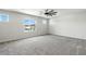 Spacious room with plush gray carpet, ceiling fan, and bright windows at 4039 Beech Fern Ave, North Las Vegas, NV 89084